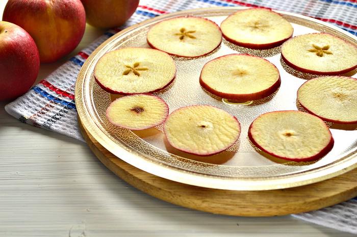 Заготовки для яблочных чипсов на стеклянной тарелке